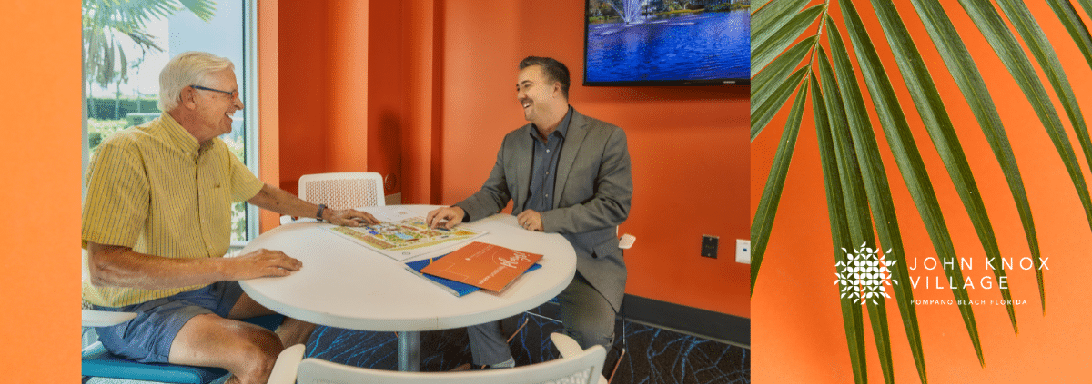 Sales Consultant at a table talking to senior man