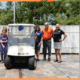 John Knox Village leadership with members of ScentsAbility posing with a golf cart JKV donated