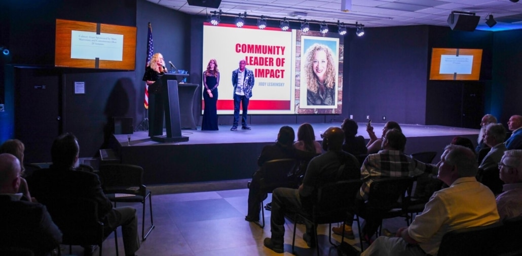 Jody Leshinsky on stage accepting an Impact Award from ArtServe