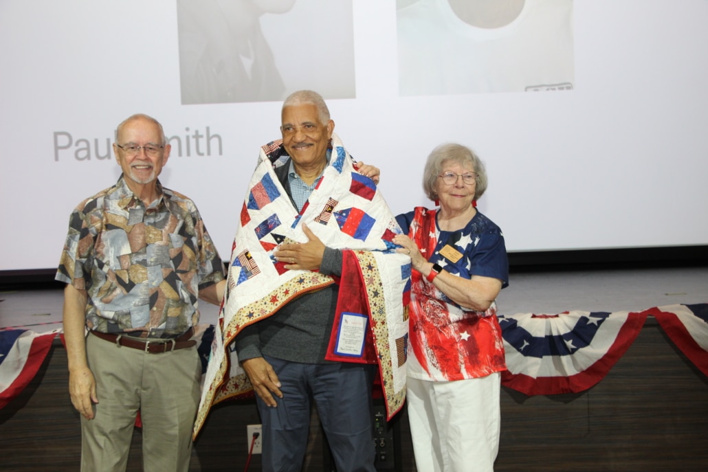 JKV resident veteran Paul Smith wrapped in a patriotic quilt